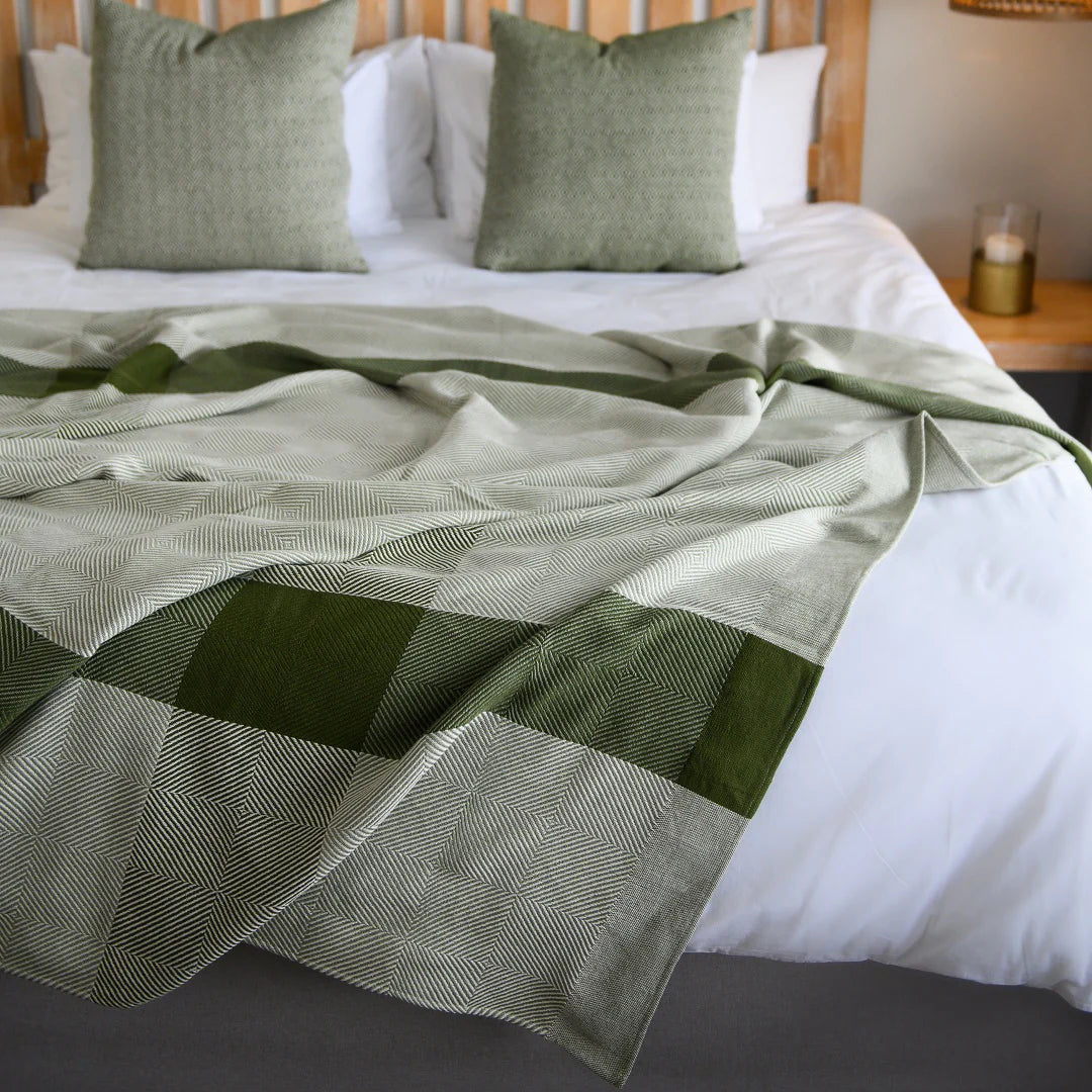 A Protea Throw featuring intricate patterns and a soft, 
luxurious texture, on a lodge bed. Its hand-knotted fringes 
add a touch of elegance, making it a perfect choice for lodges 
and guesthouses aiming to impress their guests. #LodgeLuxury 
#PremiumBlankets #GuestExperience #HospitalityExcellence 
#SouthAfricanCraftsmanship